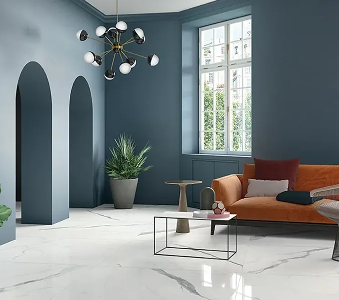 Modern interior design with large format white tiles and orange accent furniture.