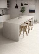 Blossom Taupe Matt Porcelain Tile flooring in modern kitchen design with island and bar stools.