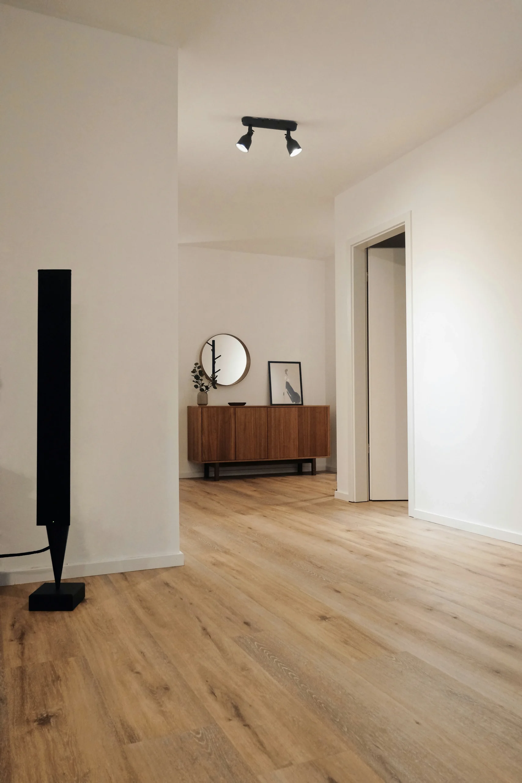 Minimalist interior with wooden floor, modern furniture, and wall art
